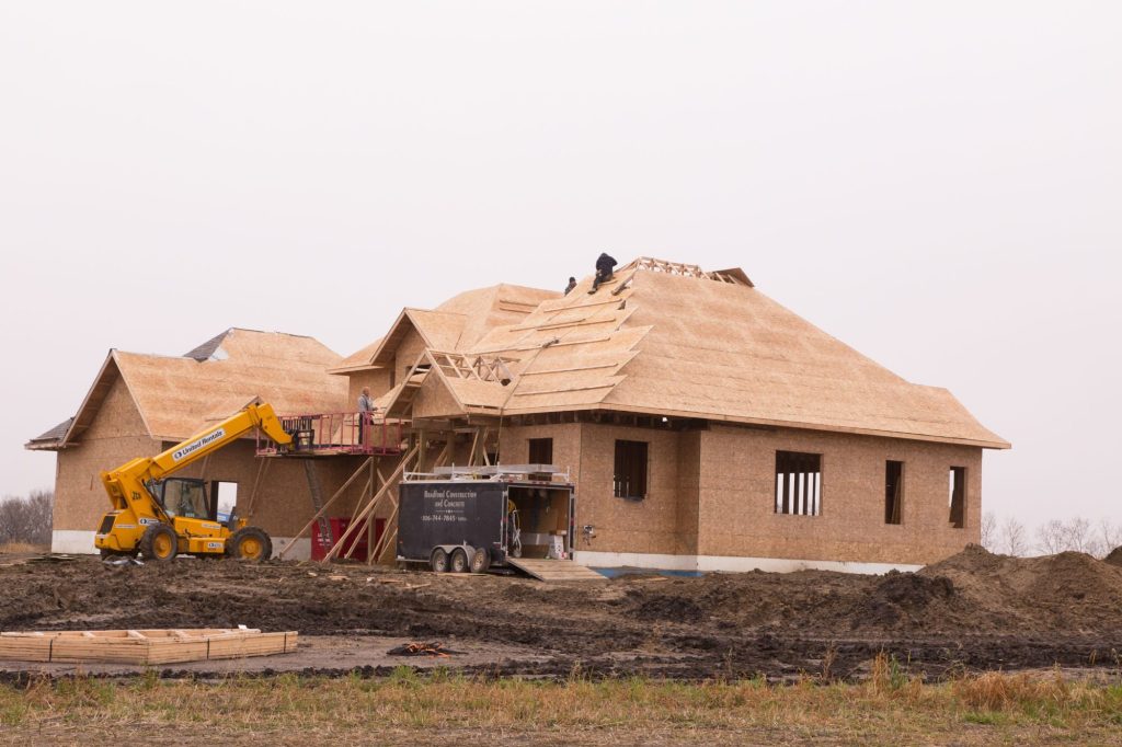 Roof framing on a Brylee Developments home build with excavator on site