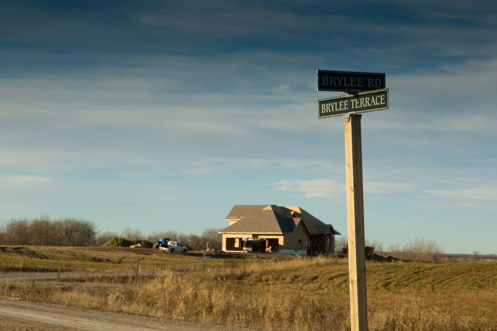 Brylee Terrace street sign with a new home on the prairie behind it