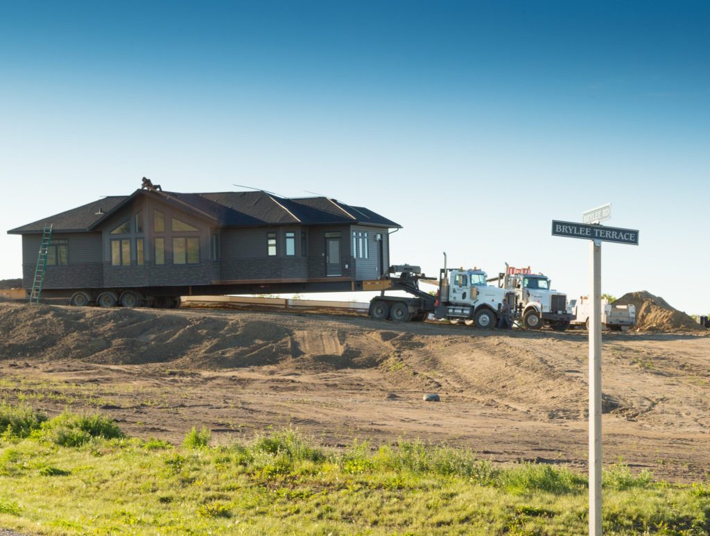Home being moved onto its lot beside the Brylee Terrace street sign
