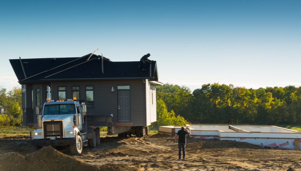 Truck positioning a ready-to-move home on a Brylee Estates lot